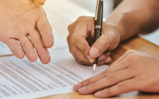 close-up-hand-holding-pen-sign-contract-on-document