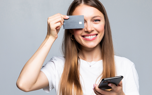 cheerful-excited-young-woman-with-mobile-phone-and-credit-card